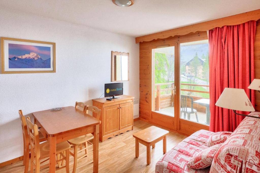 - un salon avec une table à manger et une chambre dans l'établissement Résidence Le Hameau des Ecrins - maeva Home - Appartement 2 Pièces 4 Personnes - Confort MAE-7064, à Puy-Saint-Vincent