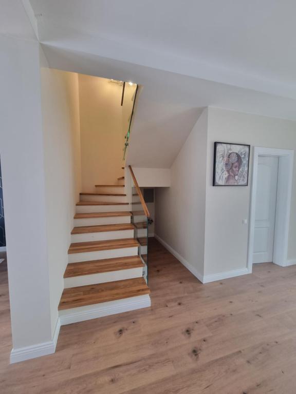 een trap in een huis met witte muren en houten vloeren bij Anca House in Baia Mare