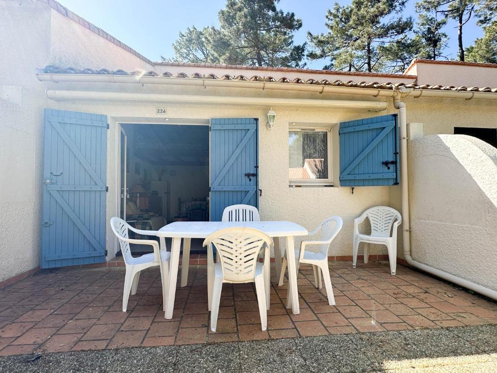 une table blanche et des chaises sur une terrasse dans l'établissement Maison T3 Mézzanine à 1 km de la plage – Terrasse privée, BBQ, parking, animaux admis, près commerces - FR-1-705-69, aux Mathes