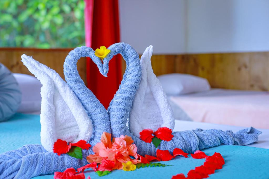 a pair of swans made out of towels on a bed at The Sunset Tucano Lodge in Drake
