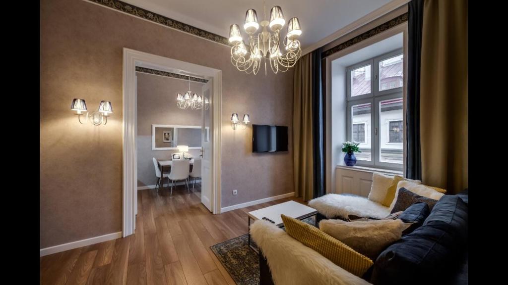 uma sala de estar com um sofá e um lustre em Lviv Apartments em Lviv