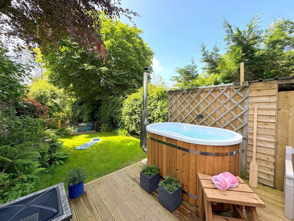 uma banheira de hidromassagem sentada num deque num quintal em 1 Bed in Barnstaple 93422 em Marwood
