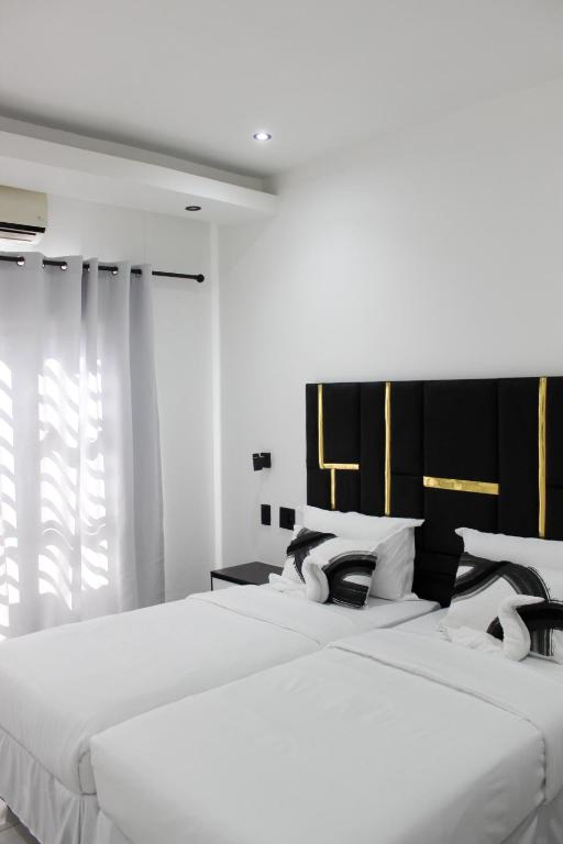 two beds in a bedroom with white walls at Esteem guesthouse Windhoek in Windhoek