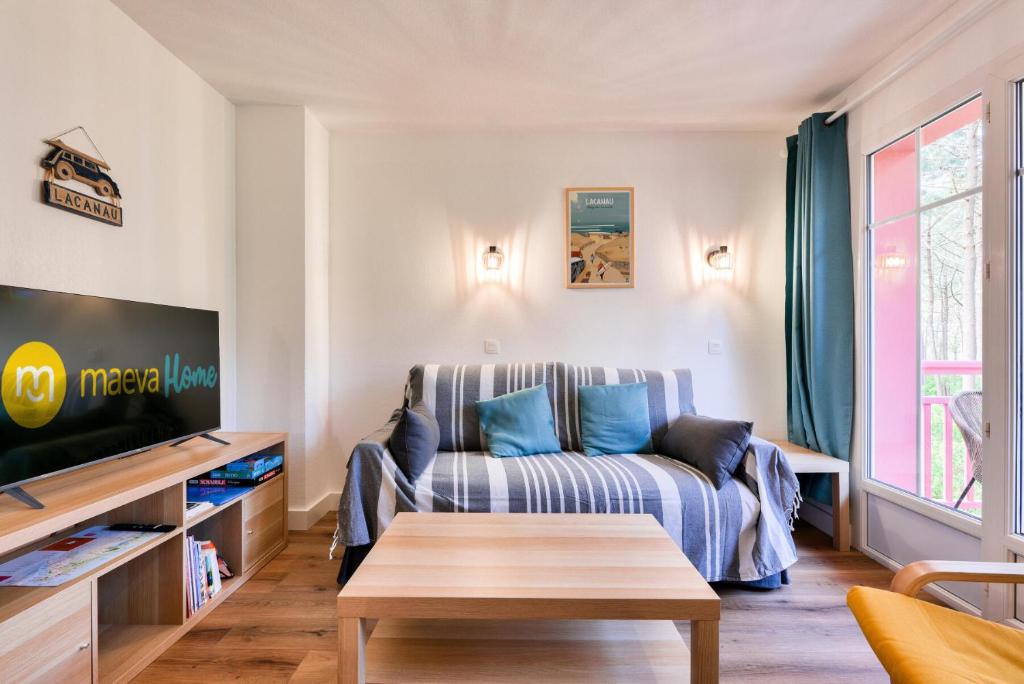 un salon avec un canapé et une télévision dans l'établissement Résidence Lacanau Les Pins - maeva Home - Appartement 2 pièces 4 personnes - Prestige MAE-6651, à Lacanau