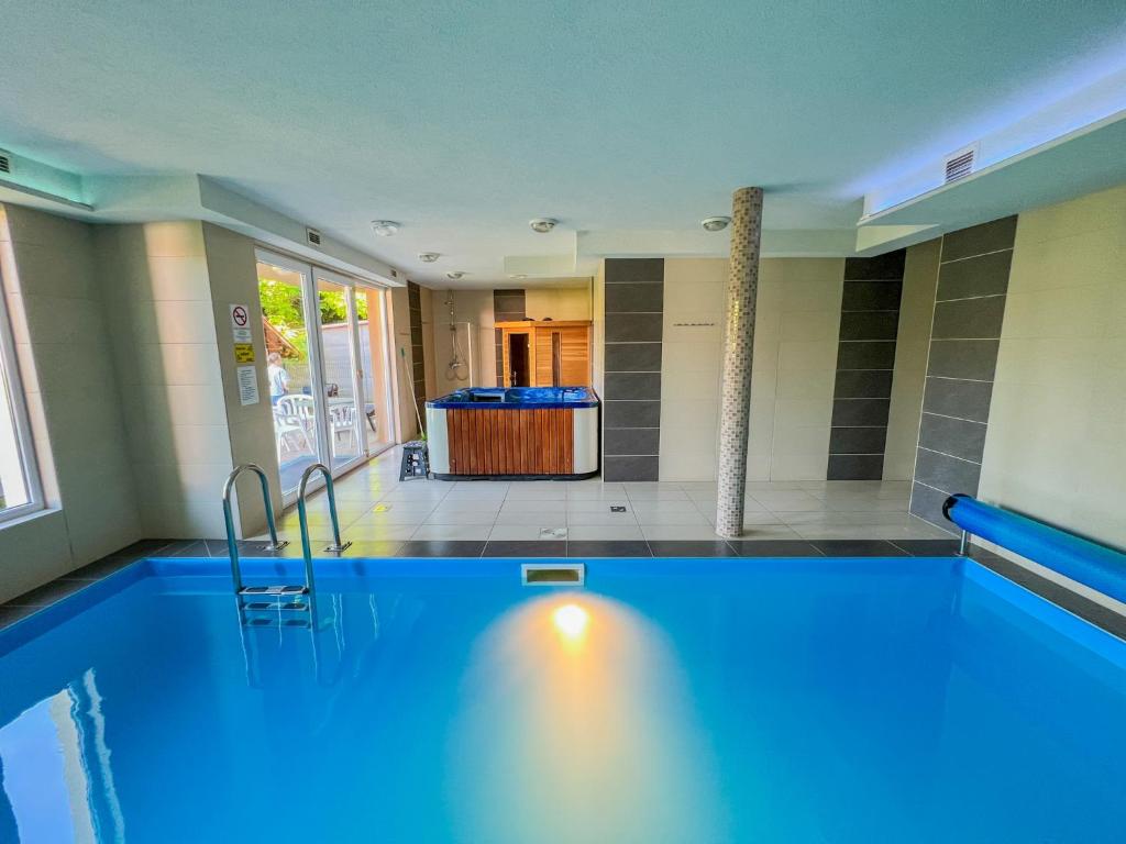 einen großen Pool in einem Zimmer mit Badewanne in der Unterkunft Relax Prémium Wellness Apartman in Siófok