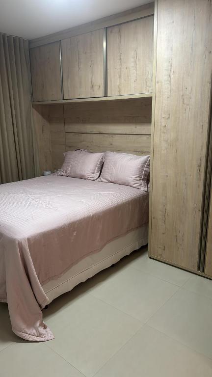 een slaapkamer met een bed met een houten hoofdeinde bij Bella House in Luis Eduardo Magalhaes