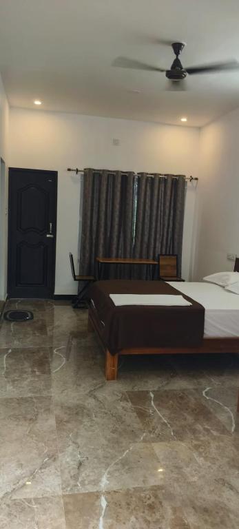 a bedroom with a large bed and a window at Dream Nest Resort in Mettuppālaiyam