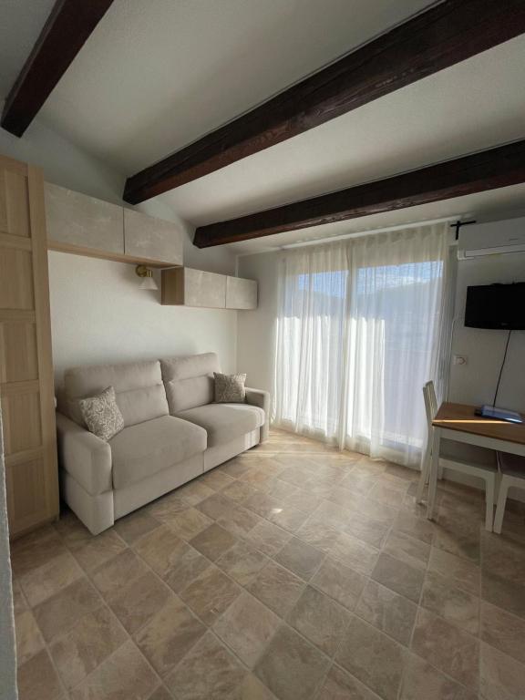 un salon avec un canapé et une table dans l'établissement Appartement Pinède Piscine Clim proche Plage village naturiste, au Cap d'Agde