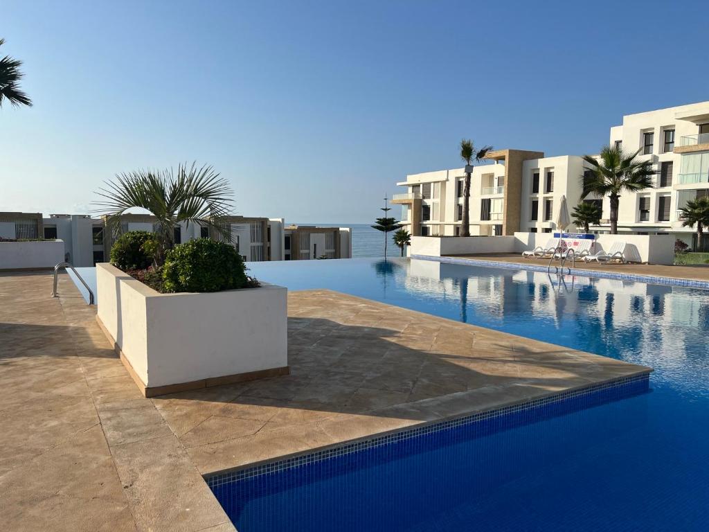 a view of a swimming pool with some buildings at 2 bedroom apartment with sea view and private pool in Sidi Bouqnadel