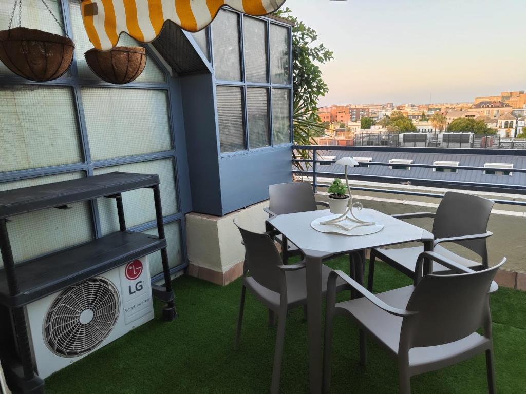 a balcony with a table and chairs and a fan at Agradable Dúplex Terraza Virgen del Rocio in Seville