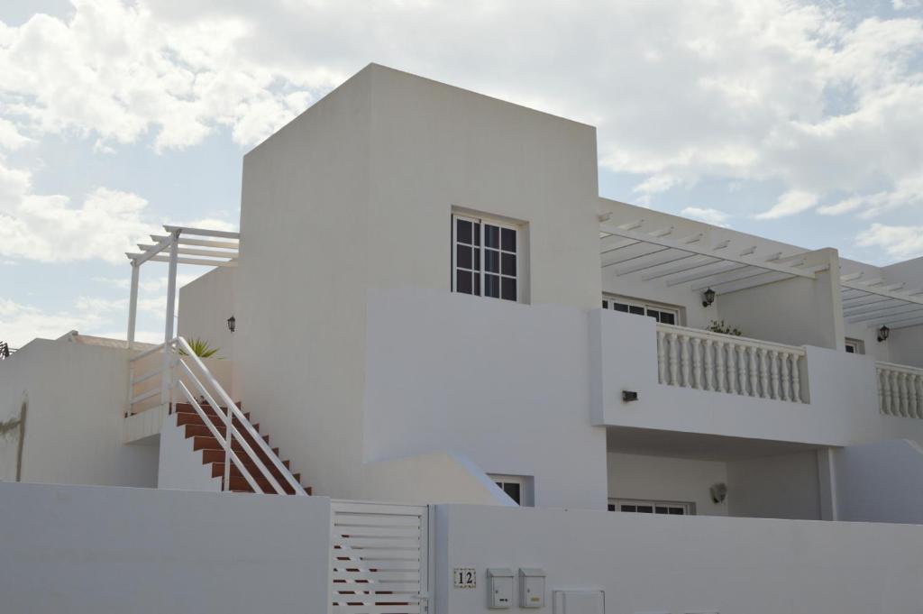 ein weißes Gebäude mit einer Treppe davor in der Unterkunft Apartamento PLAYA HONDA I - Home Beach in Playa Honda