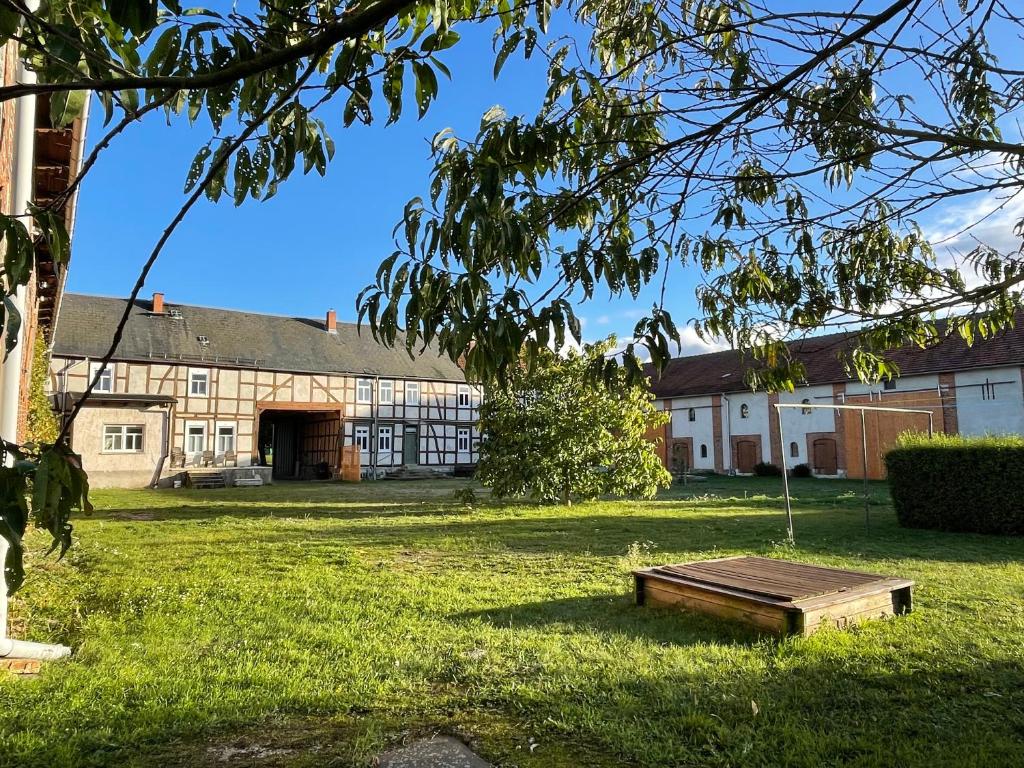 Un edificio en un campo con un banco en el césped. en Ferienhof Bühne, en Bühne