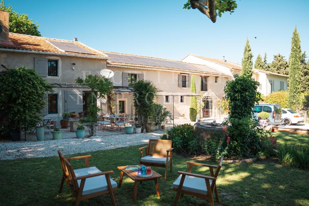 une cour avec des chaises et une table en face d'une maison dans l'établissement Mas de l'air, à Noves