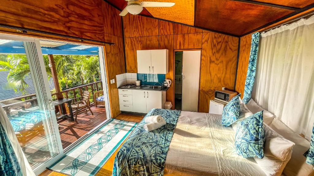 una camera con letto e una cucina con balcone di Ariki Retreat Adults Only - Part of the ARIKI EXPERIENCE a Rarotonga