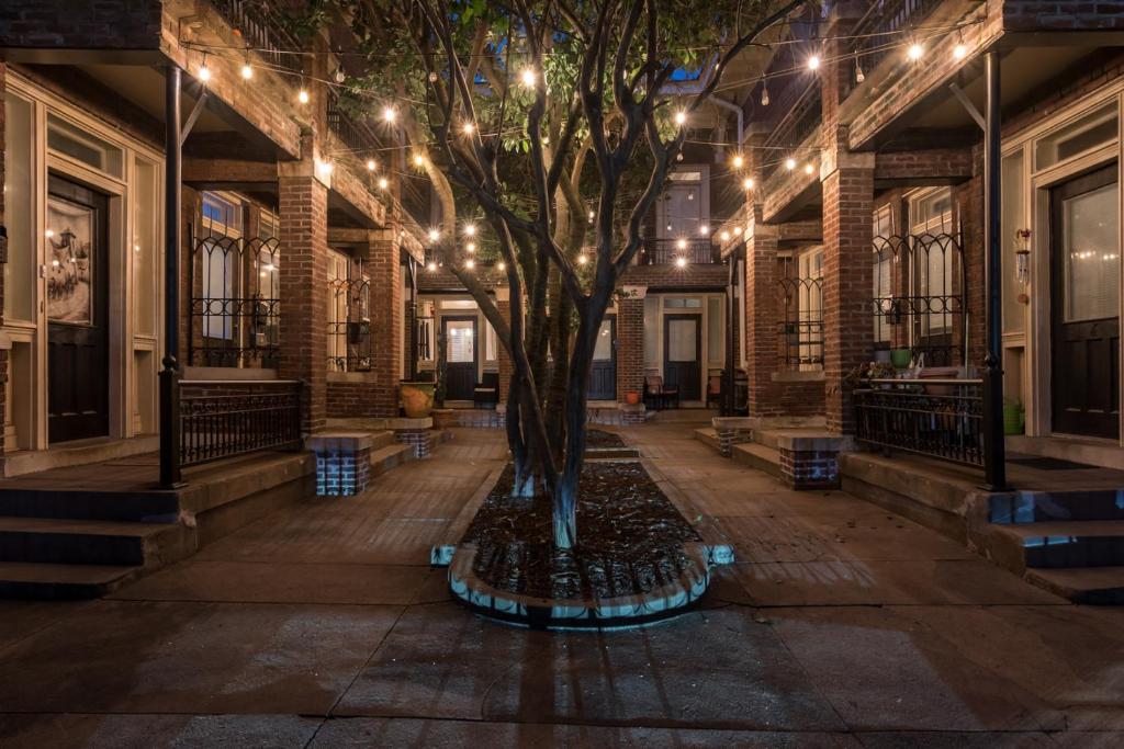 a tree in the middle of a building with lights at Chateaus at St Clair in Downtown Little Rock in Little Rock