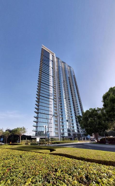 een hoog gebouw met een park ervoor bij Apartment 1015 Waves in Dubai