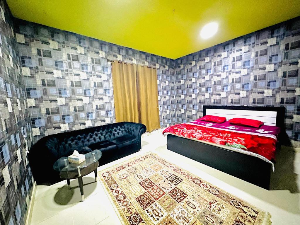 アジュマーンにあるRoyal Suite: King Comfortのベッドルーム1室(ベッド1台、ソファ、ラグ付)