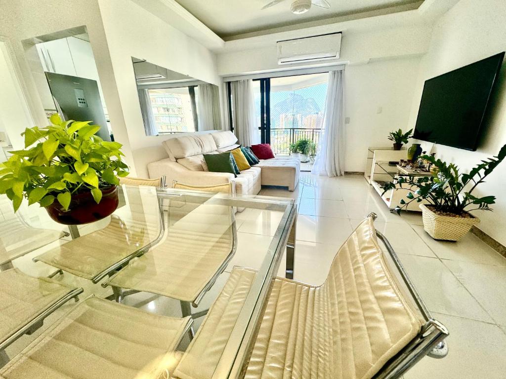 uma sala de estar com uma mesa de vidro e cadeiras em Flat Mar Montanha Four Seasons no Rio de Janeiro