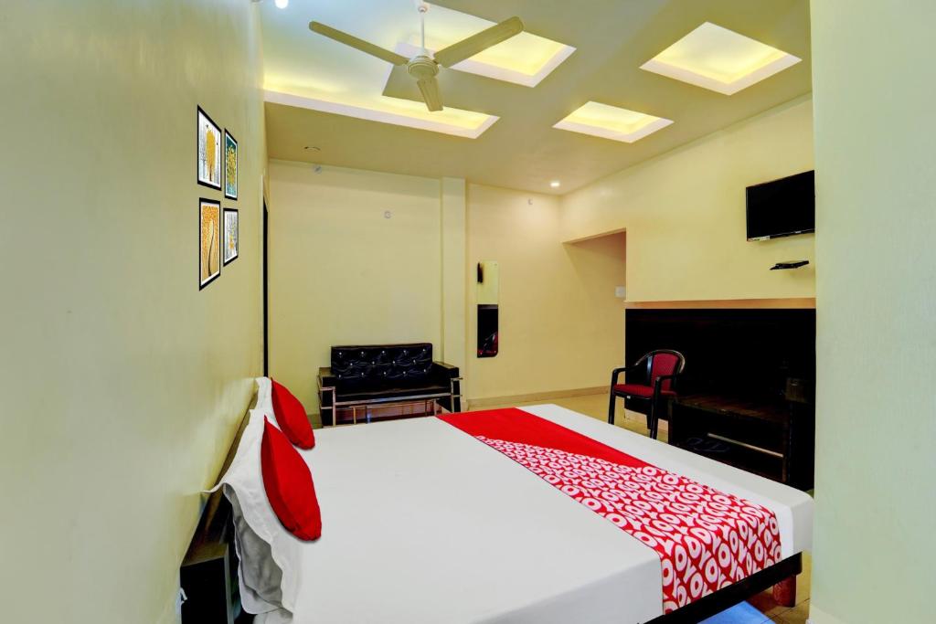 1 dormitorio con cama blanca y manta roja en OYO Flagship Hotel Centre Point, en Chupra