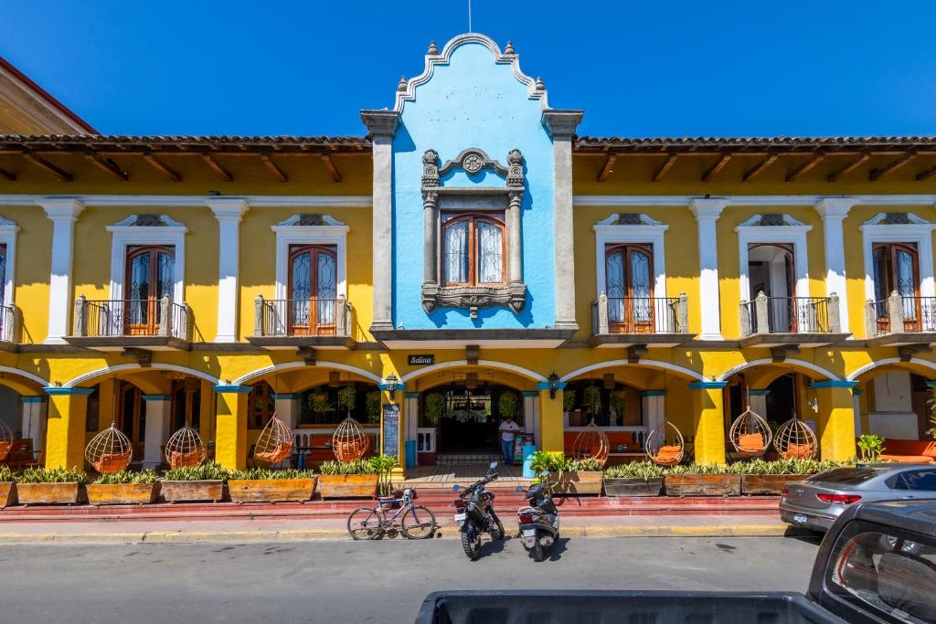 un bâtiment jaune avec des vélos garés devant lui dans l'établissement Selina Granada, à Granada