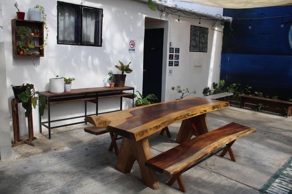 drewniany stół i ławki w pokoju w obiekcie The Boat House Cancun w mieście Cancún