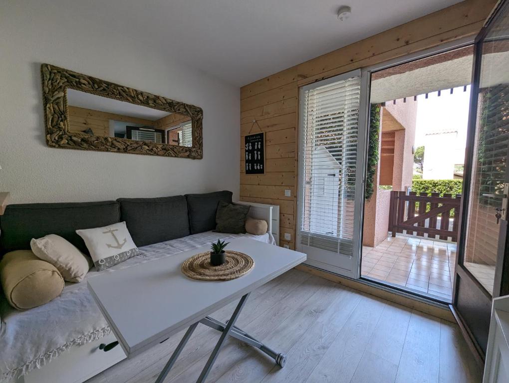 un salon avec un canapé et une table dans l'établissement Appartement bord de mer, piscine et Wifi, à Saint-Cyprien