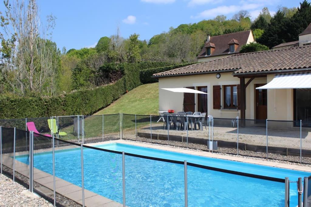 une piscine avec une clôture à côté d'une maison dans l'établissement Maison 6 personnes piscine privée proche Sarlat, à Proissans