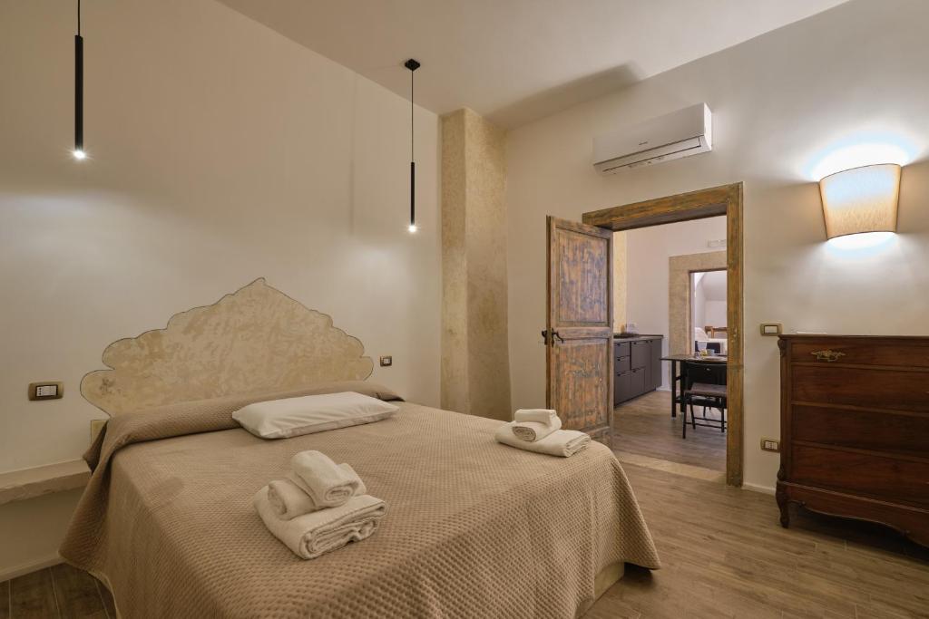 a bedroom with a bed with towels on it at Makó House - in centro città in Andria