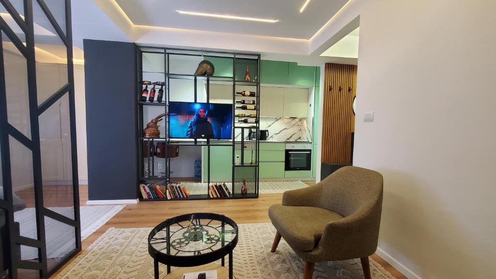 uma sala de estar com uma cadeira e uma televisão em Luki's Centre Apartment em Pristina