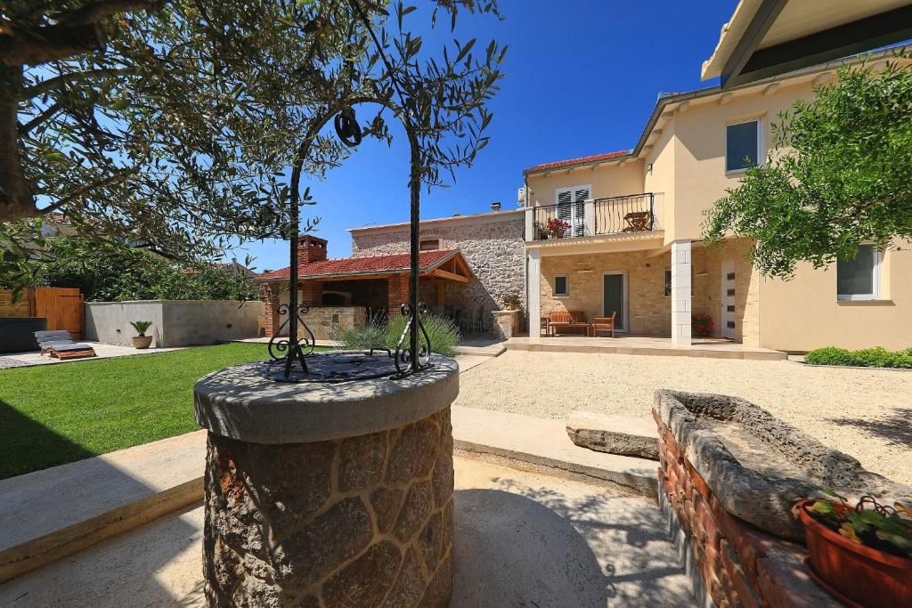 a tree in a stone planter in front of a house at House Bona in Sukošan