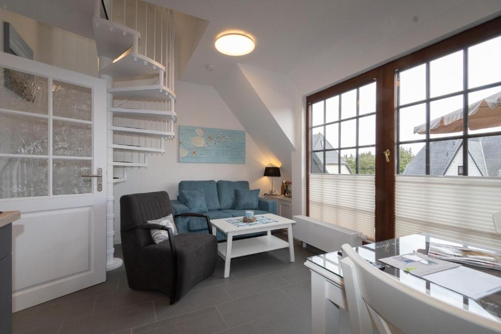 a living room with a blue couch and a table at Rüm Hart II, Weestersir in Hörnum