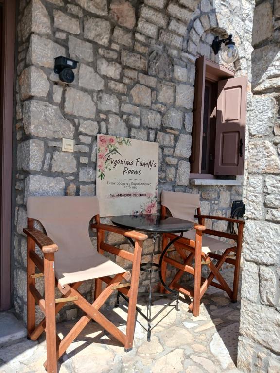 une table et des chaises à côté d'un mur en pierre dans l'établissement Avgonima Family's Rooms Grandfather Michalis1, à Chios