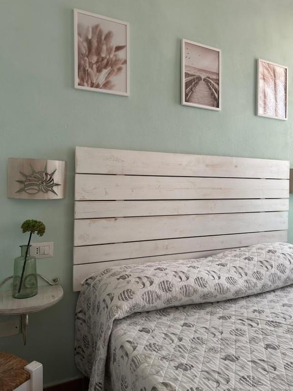 ein Schlafzimmer mit einem Bett und drei Bildern an der Wand in der Unterkunft Palazzo Antico in Santa Teresa Gallura