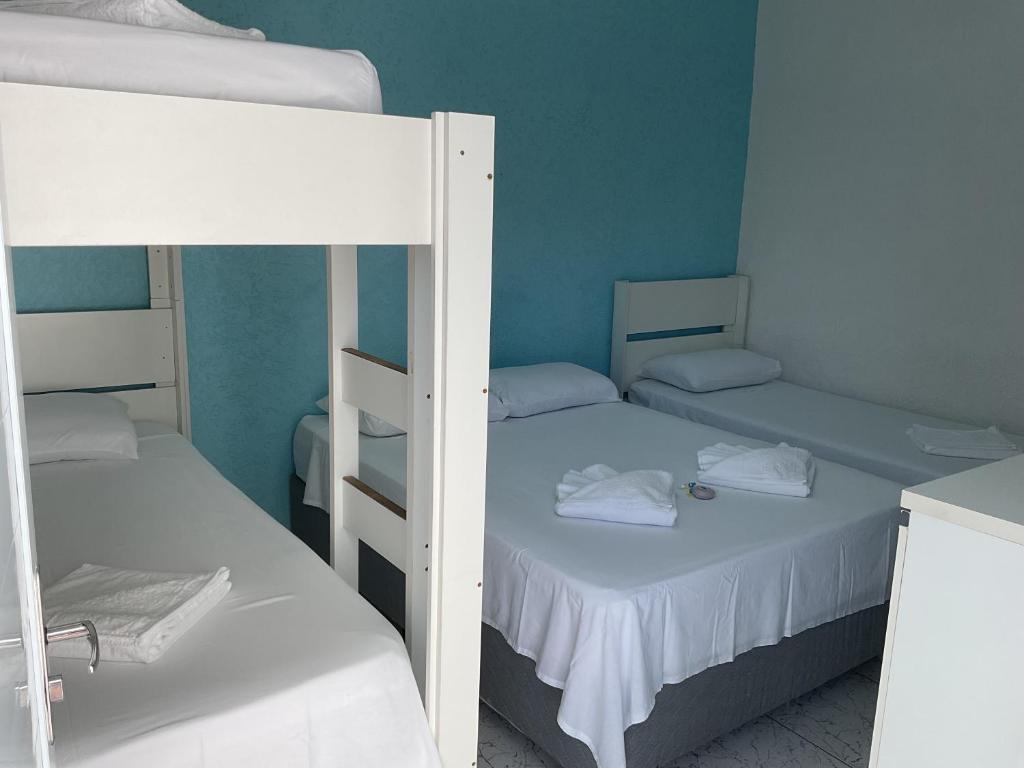 two bunk beds in a room with blue walls at Pousada Sol & Mar in Ubatuba