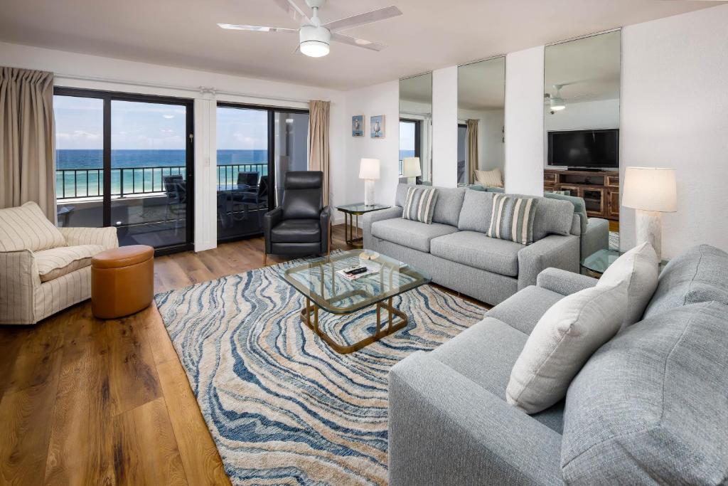 uma sala de estar com um sofá e uma mesa em Surf Dweller 406 condo em Fort Walton Beach