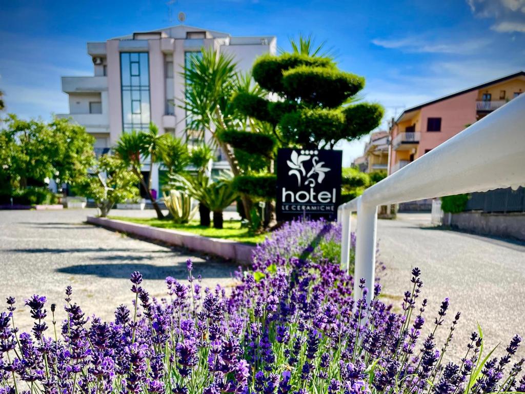 un jardín con flores púrpuras frente a un hotel en Le Ceramiche - Hotel Residence ed Eventi en Montalto Uffugo