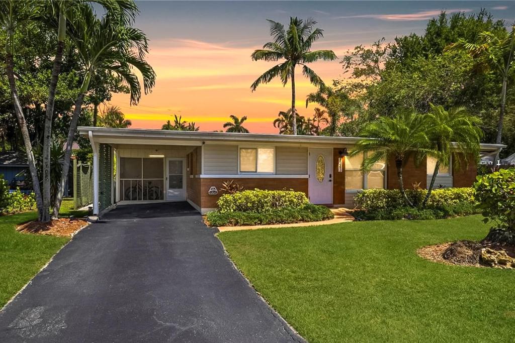 a house with palm trees and a driveway at The Naples Bungalow in Naples