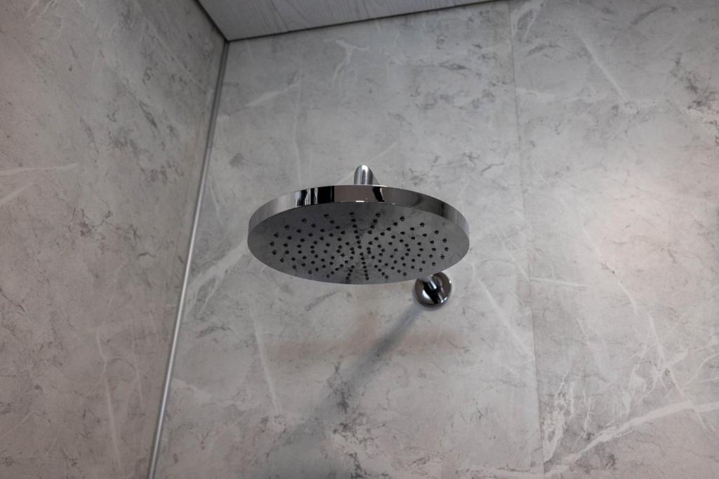 a shower with a round shower head in a bathroom at Dis Cottages in Grundarfjordur