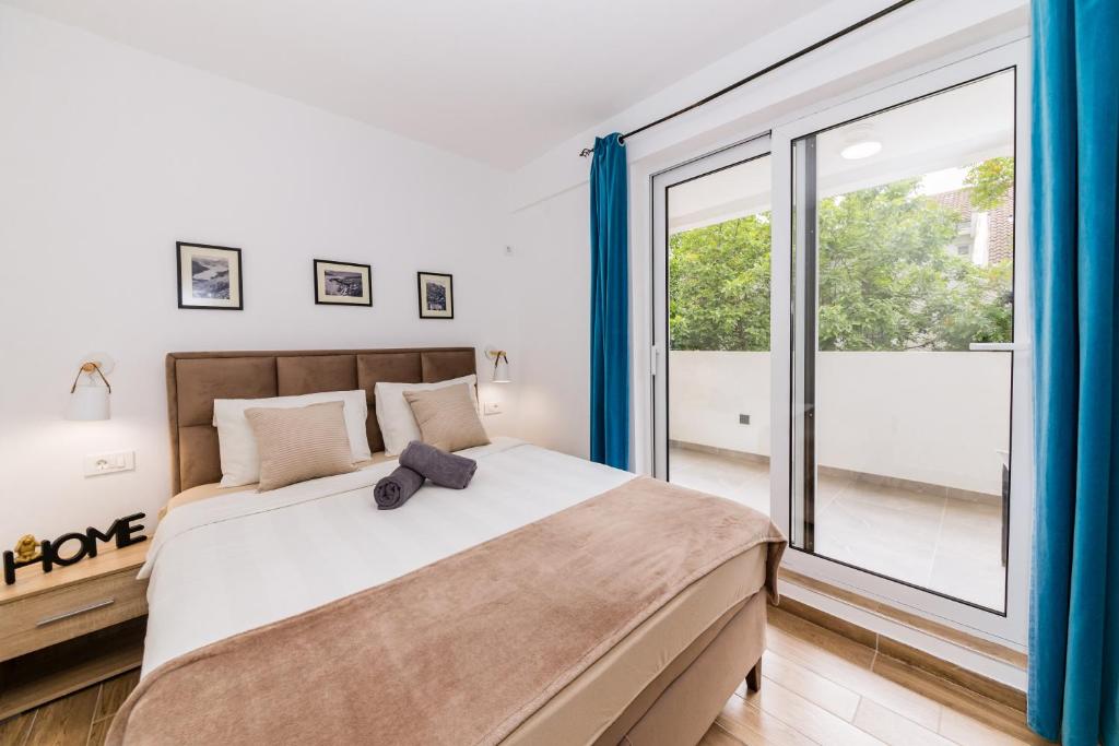 科托尔Paun apartment的一间卧室，配有一张大床和一扇大窗户。