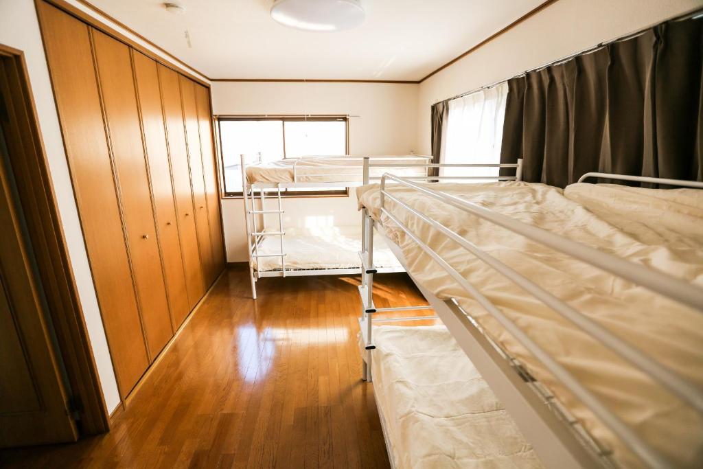 um quarto com 2 beliches e um closet em J's Backpackers em Tóquio