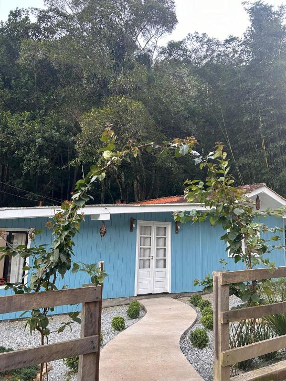 a blue house with a fence in front of it at Morada encanto da cachoeira in Aguas Mornas