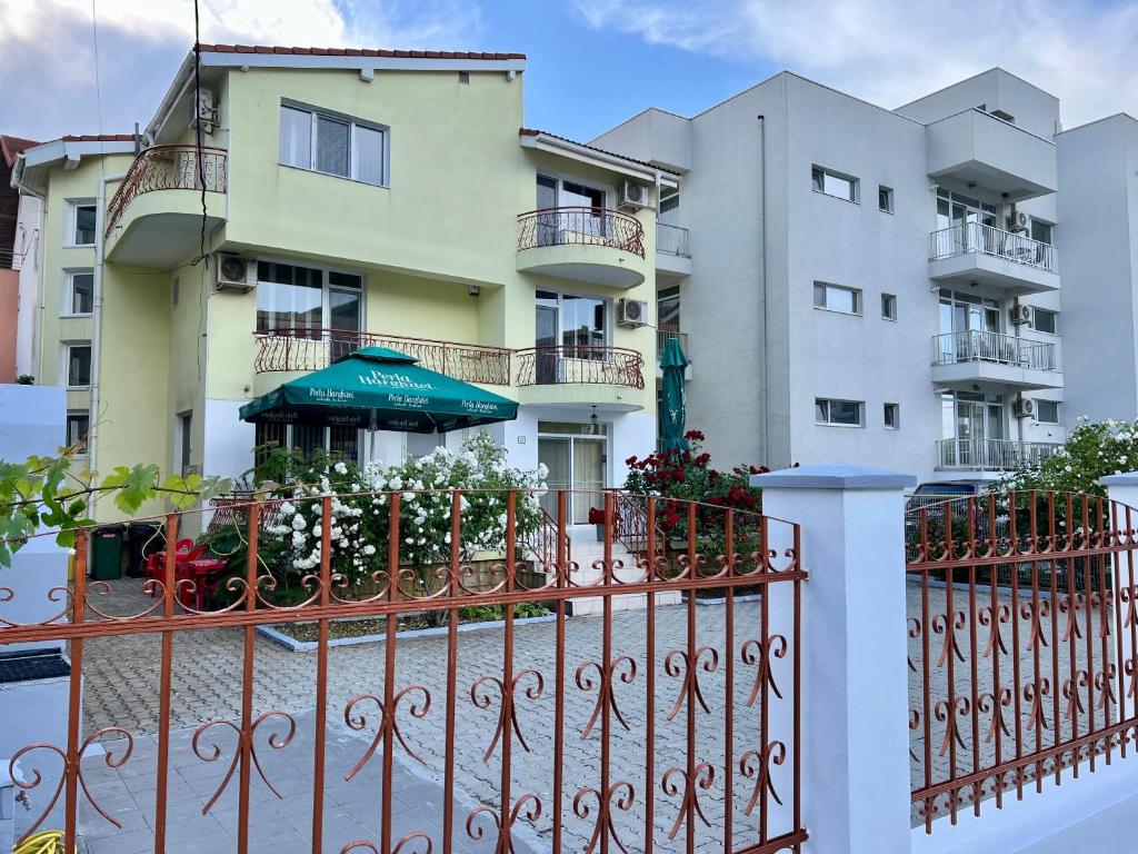 an apartment building with a fence and an umbrella at Casa Servus Junior in Mamaia Nord