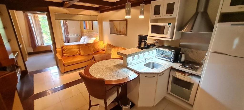 a kitchen with a table and a counter top at Luxuoso Flat no Laje de Pedra -Mountain Village in Canela