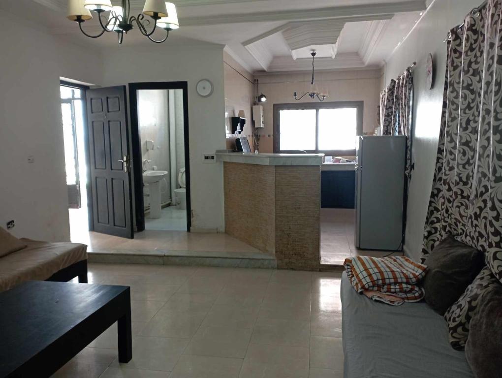 een woonkamer met een bank en een keuken bij Le petit VIP in 'Aïn el Turk
