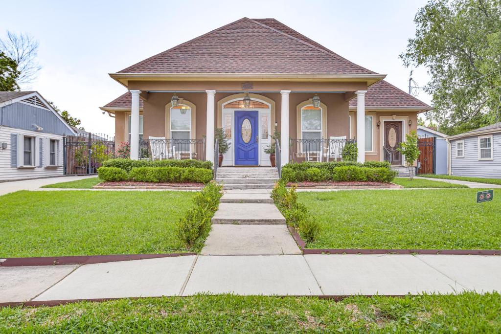 a house with a blue door and grass at 5 Mi to Bourbon St NOLA Home with Fenced Yard! in New Orleans