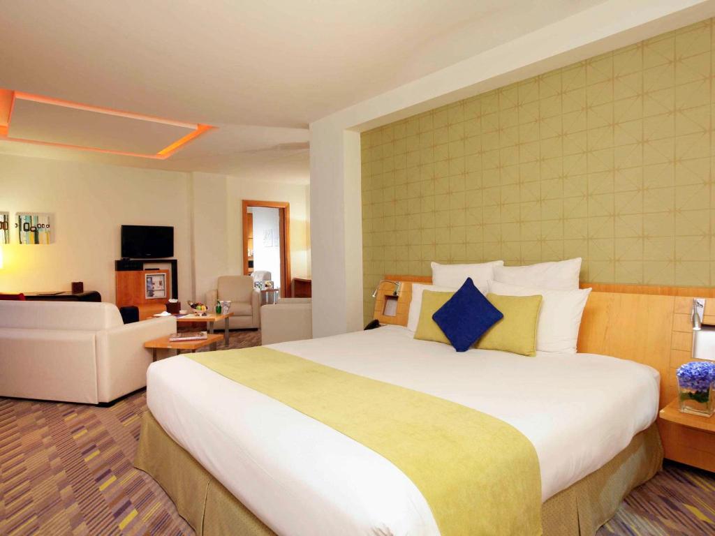 sypialnia z dużym łóżkiem i salonem w obiekcie Novotel Dammam Business Park w mieście Dammam