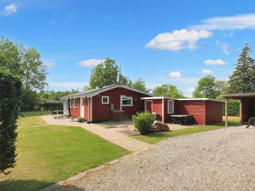 a small red and white house in a yard at 6 person holiday home in Storvorde in Storvorde
