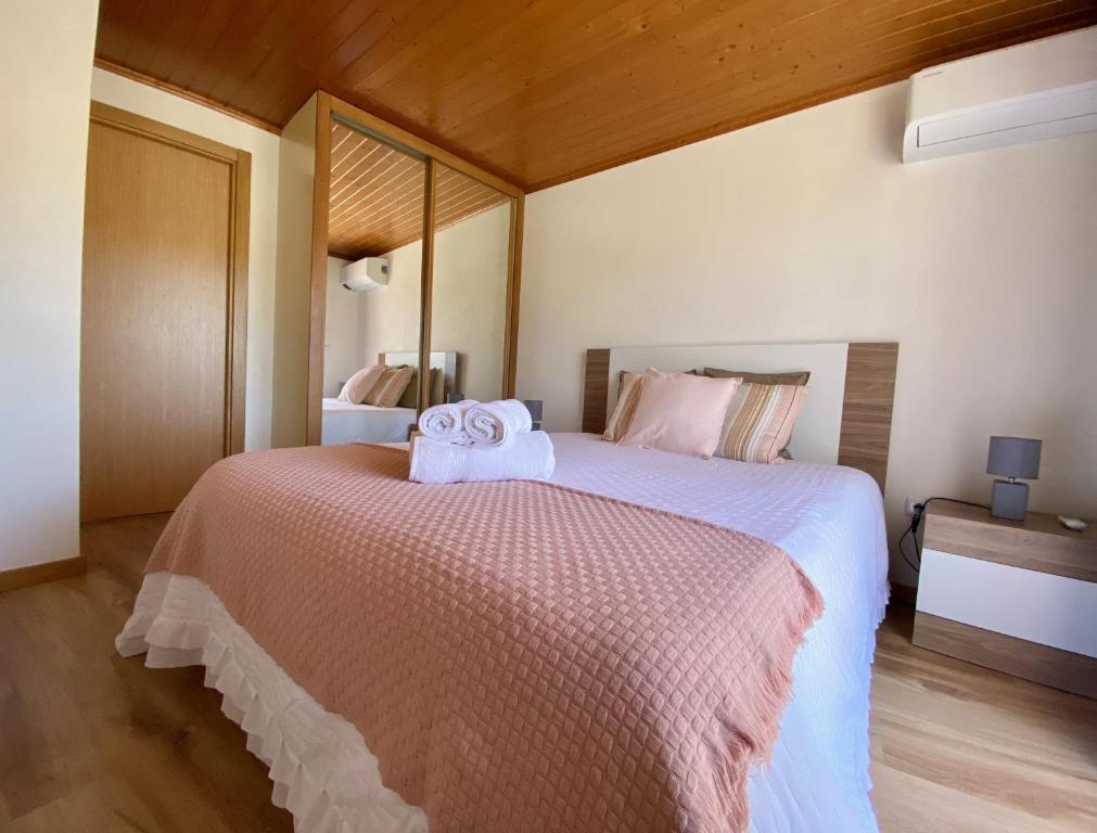 ein Schlafzimmer mit einem großen Bett mit Handtüchern darauf in der Unterkunft Casinha da Ti'Augusta in Lamego