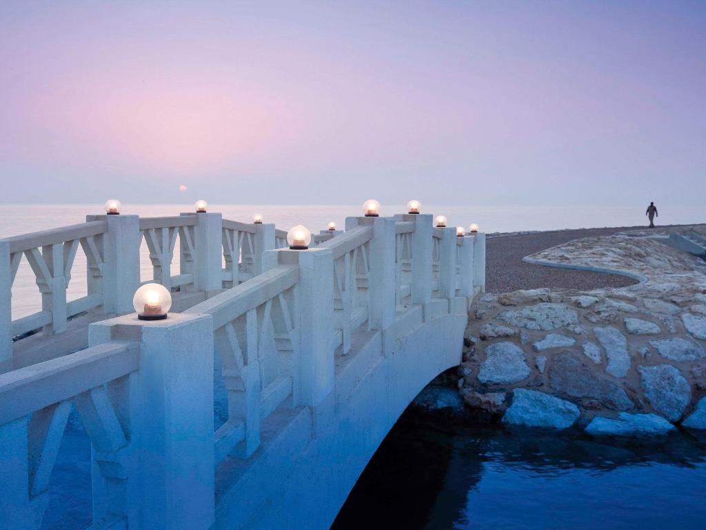 un puente blanco sobre un cuerpo de agua en Mövenpick Beach Resort Al Khobar, en Bahía de la Media Luna