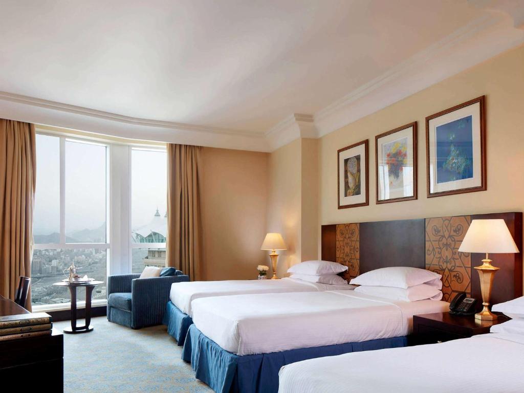 um quarto de hotel com duas camas e uma janela em Pullman ZamZam Makkah em Meca